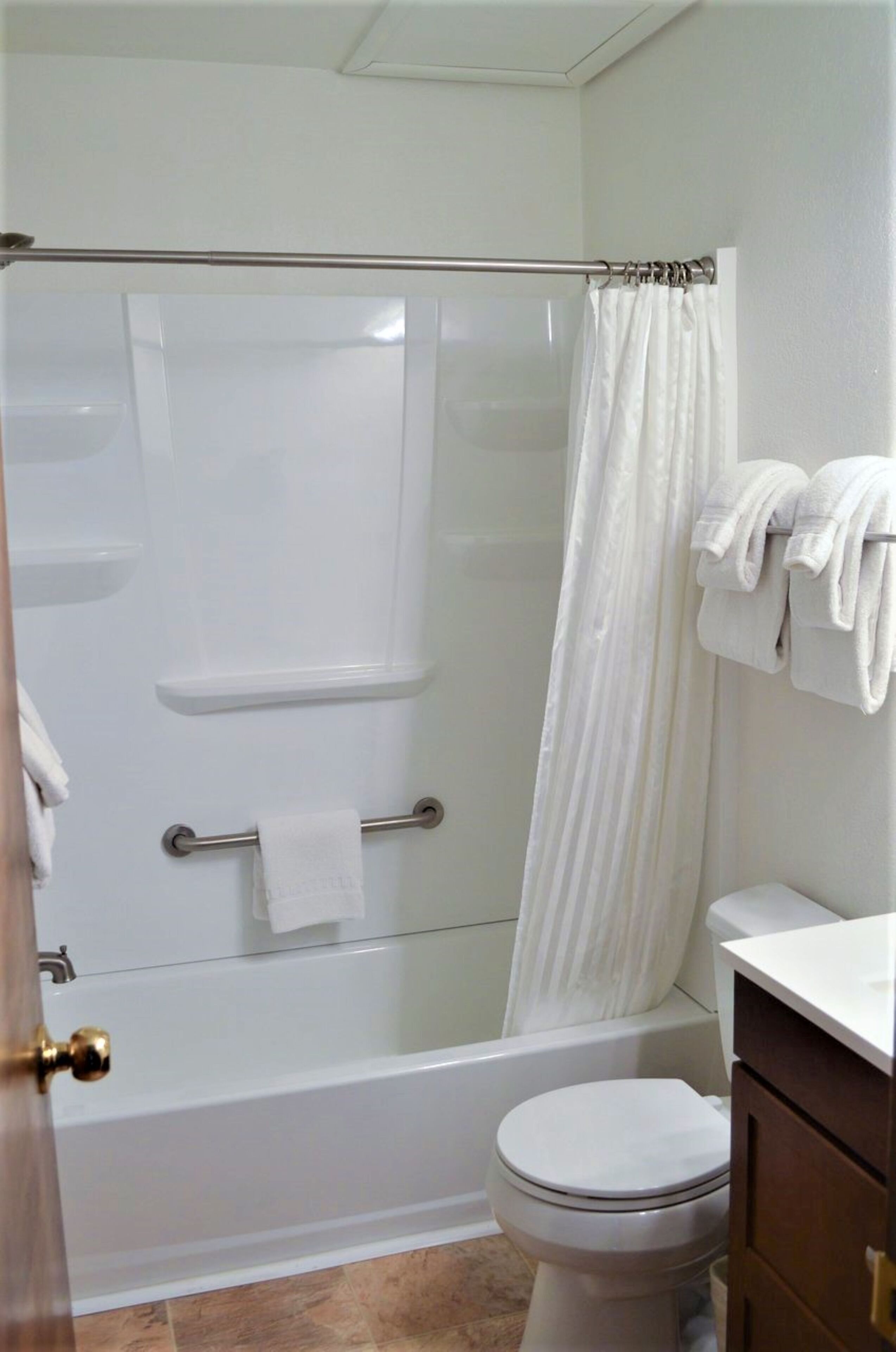 Ein Badezimmer mit Duschkabine, Toilette und Handtuchhalter.