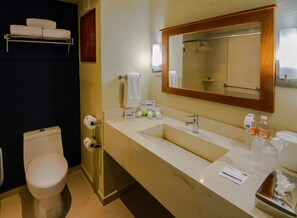 A bathroom with a toilet, sink, and mirror. There are towels and toiletries on the sink counter. - Holiday Inn Express Cabo San Lucas by IHG (Cabo San Lucas)