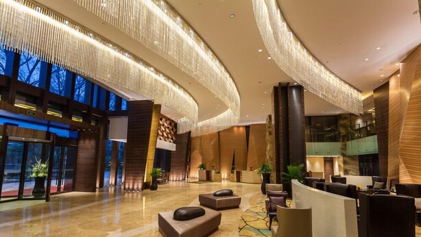 A modern lobby with a curved ceiling, seating areas, and a reception desk. - Grand Skylight International Hotel Guiyang (Guiyang)