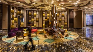 A lobby with a central seating area, a large tree sculpture, and a marble floor. - Grand Skylight International Hotel Guiyang (Guiyang)