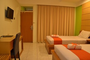 A hotel room with two beds, a desk, a chair, and a television.