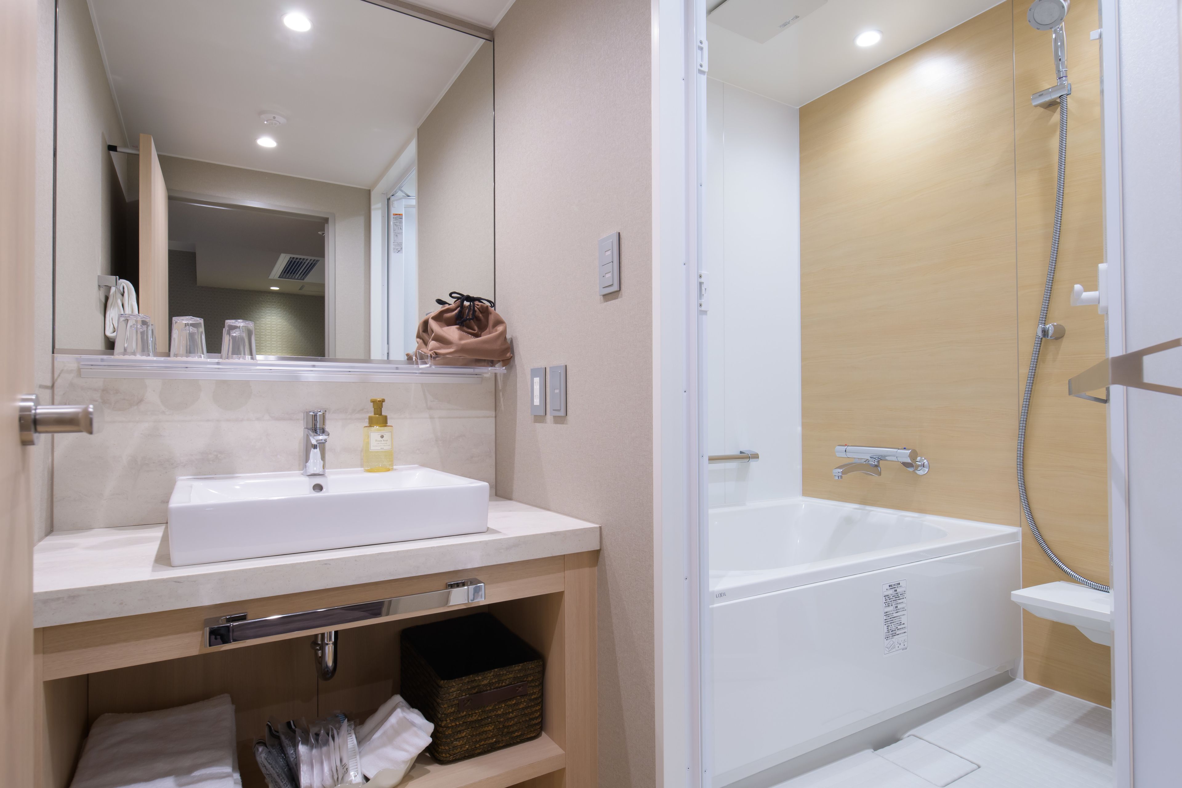 A modern bathroom with a white sink, mirror, and a walk-in shower.