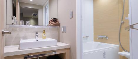 A modern bathroom with a white sink, mirror, and a walk-in shower.