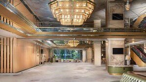 A spacious lobby with a grand chandelier, a green leather sofa, and a staircase. - Nara Royal Hotel (Nara)
