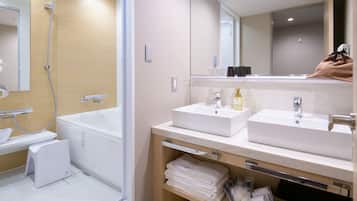 A modern bathroom with a bathtub, two sinks, and a mirror.