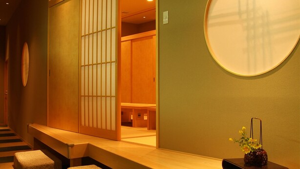 A traditional Japanese room with tatami flooring, a sliding door, and a round mirror on the wall. - Nara Royal Hotel (Nara)