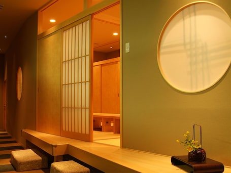 A traditional Japanese room with tatami flooring, a sliding door, and a round mirror on the wall.
