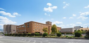 A multi-story building with a flat roof, a central tower, and a sign indicating it is a hotel. - Nara Royal Hotel (Nara)