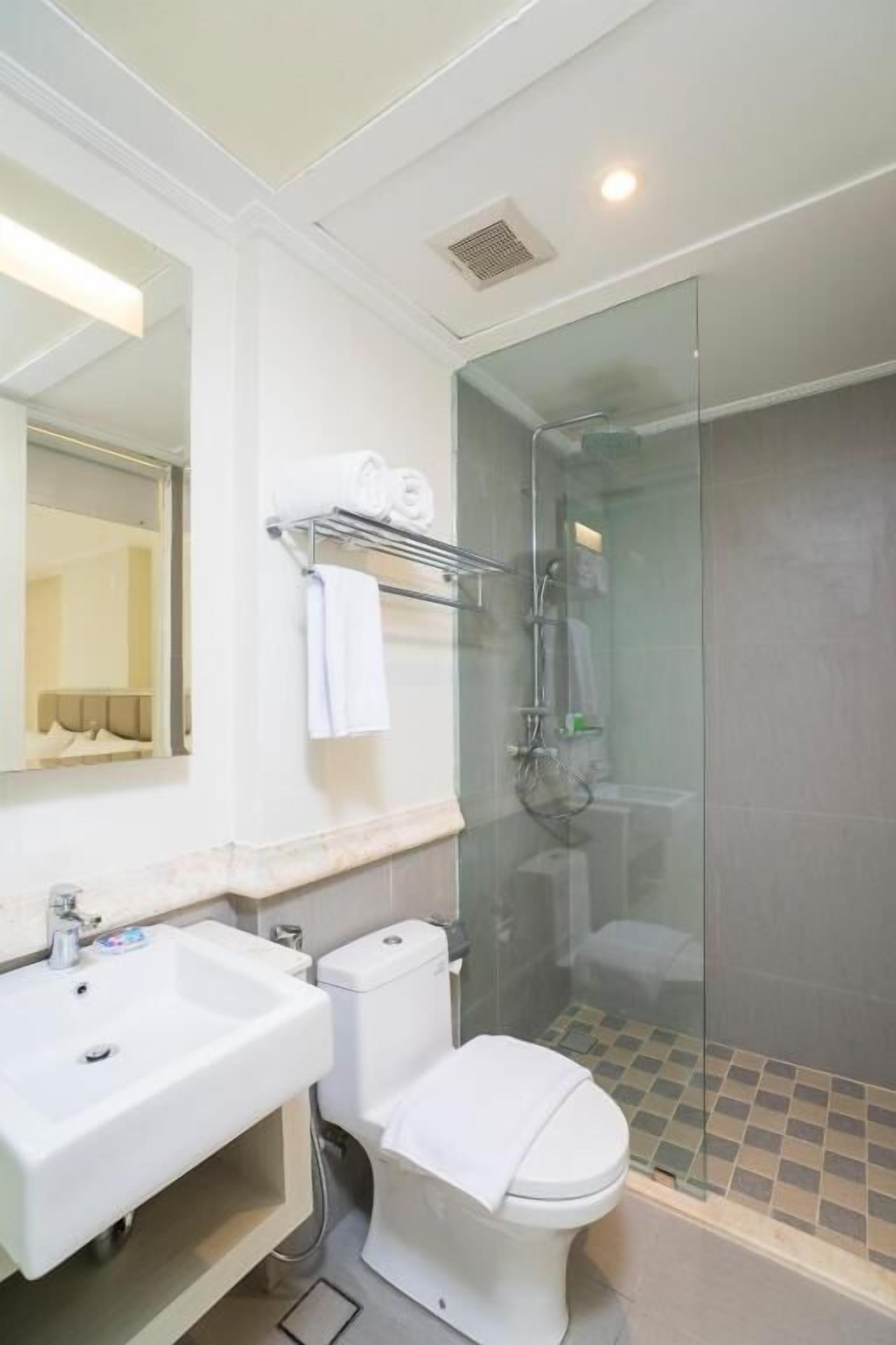 A bathroom with a sink, toilet, and glass-enclosed shower.