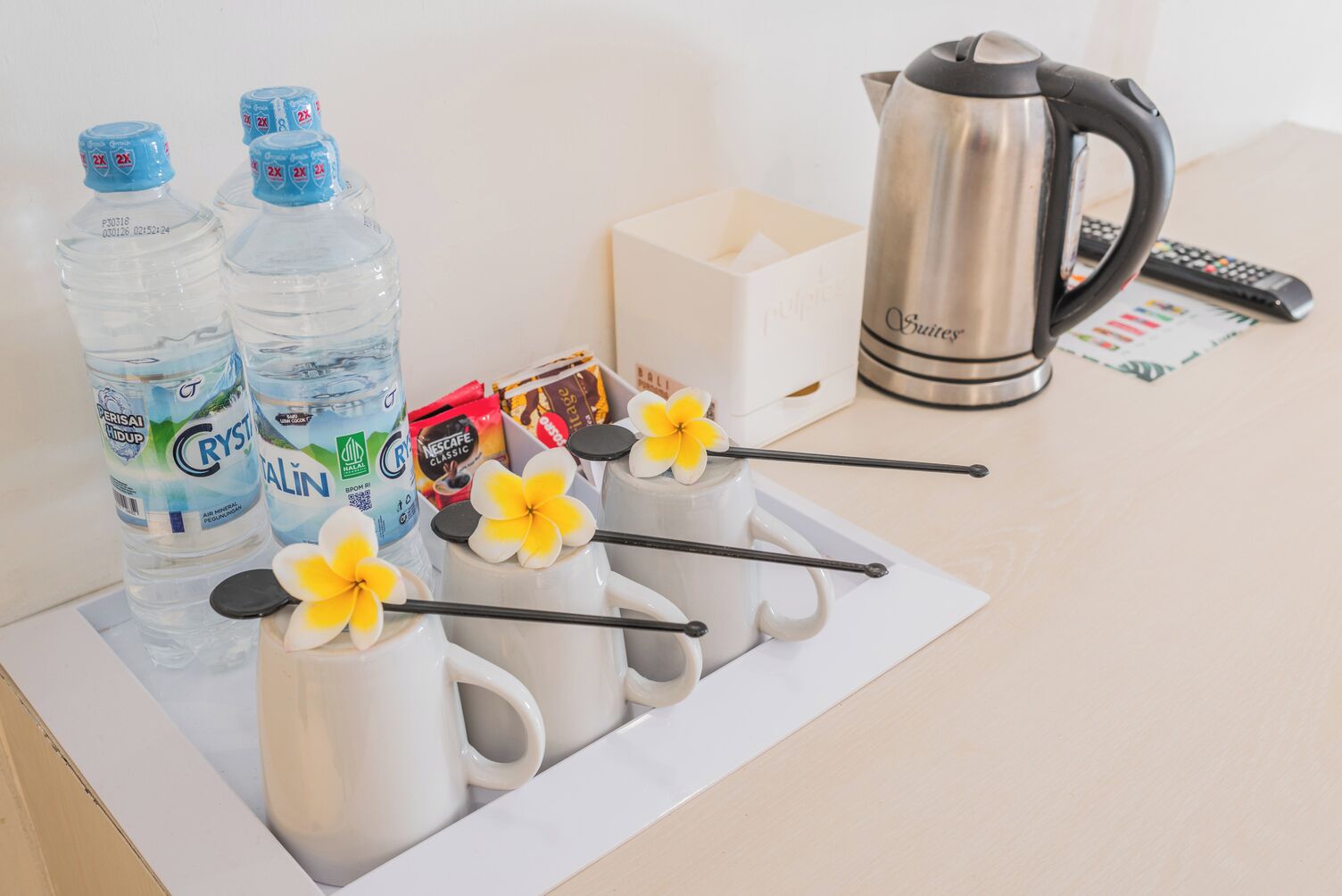 Una bandeja con botellas de agua, una cafetera y una caja de pañuelos.