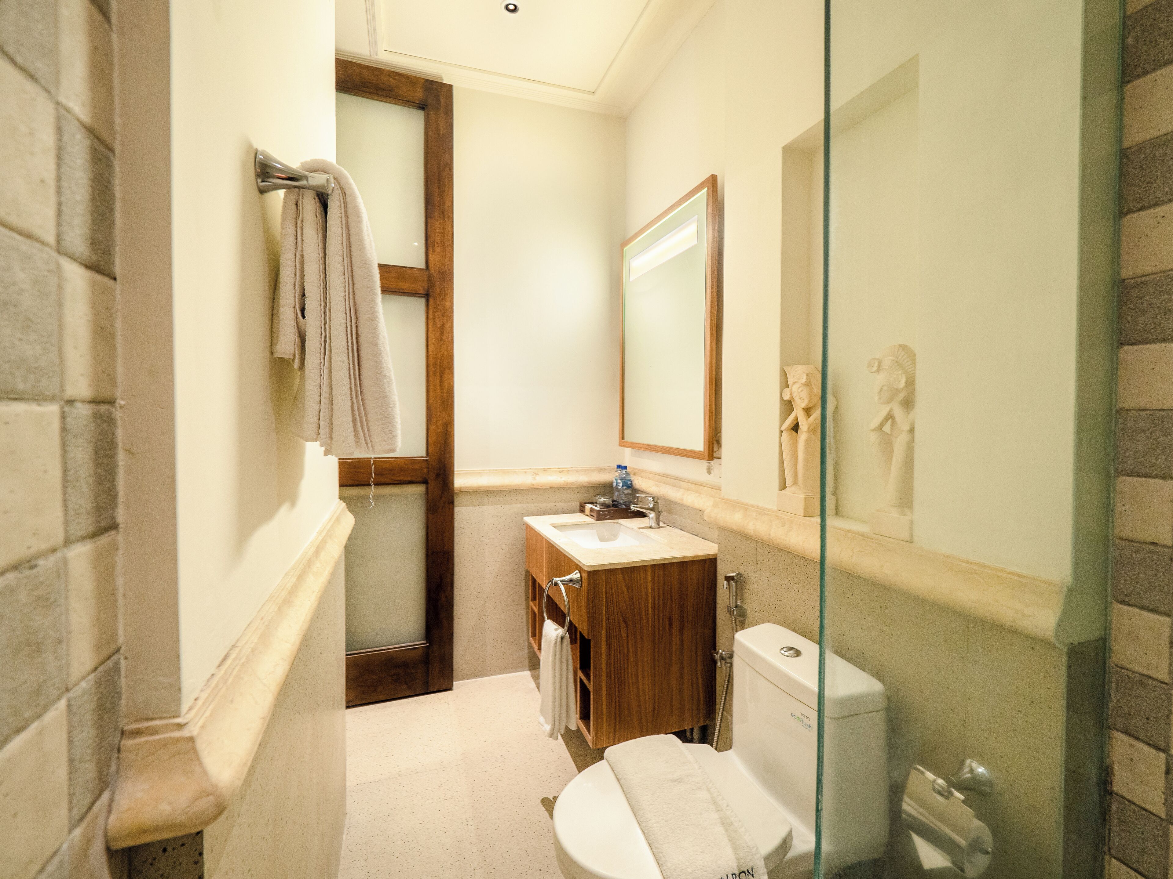 A bathroom with a toilet, sink, and glass shower enclosure.