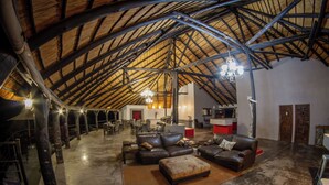 Spazioso loft con soffitto alto, travi a vista e zona salotto centrale con divani in pelle e un tavolino da caffè.