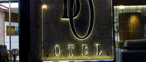 A sign for Bella Hotel with illuminated letters.