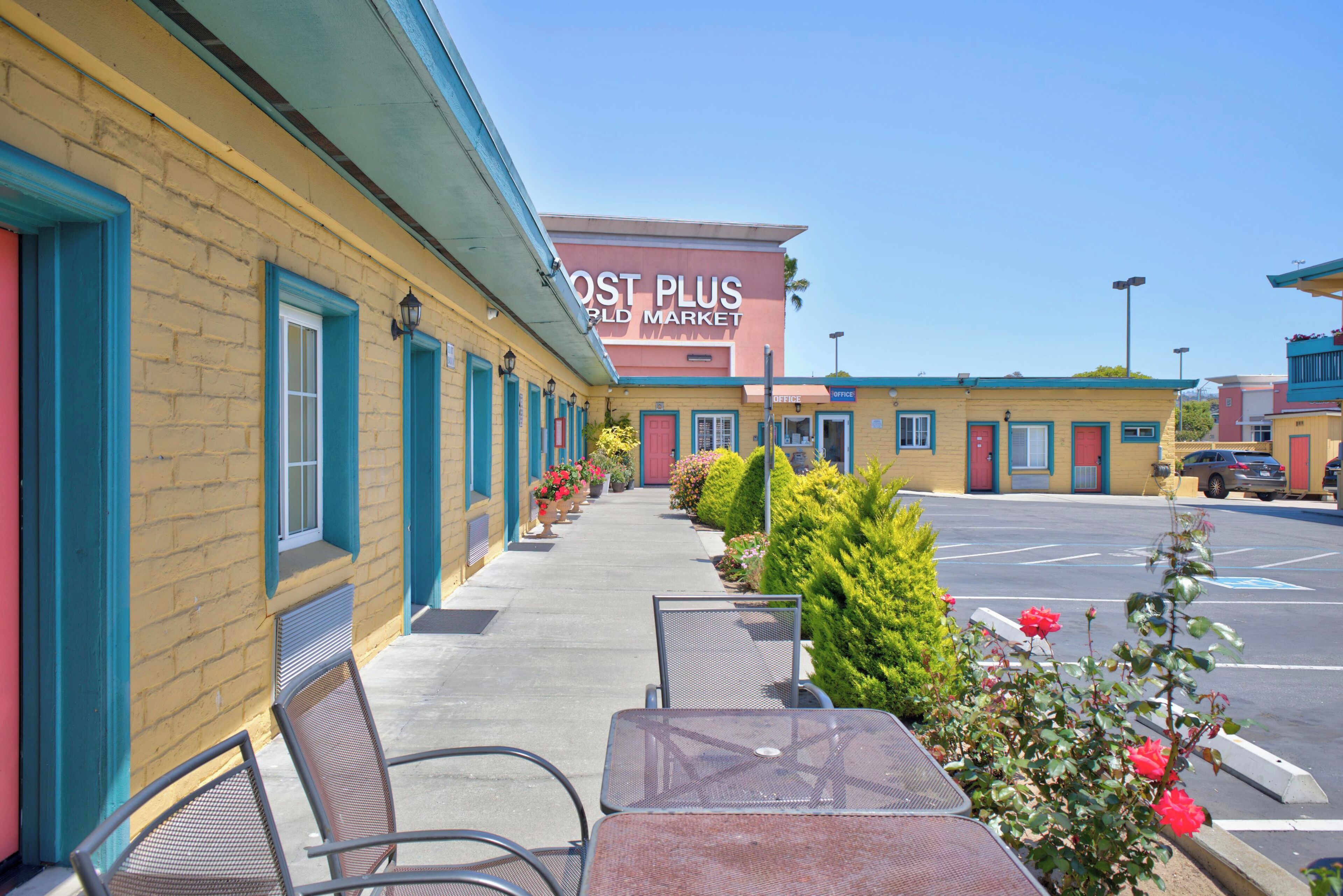 A motel with outdoor seating and a parking lot.