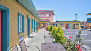 A motel with outdoor seating and a parking lot.