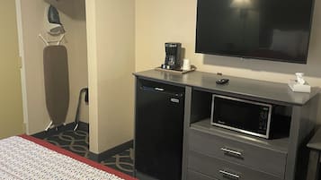 A hotel room with a bed, a TV, a coffee maker, a mini-fridge, and a microwave.