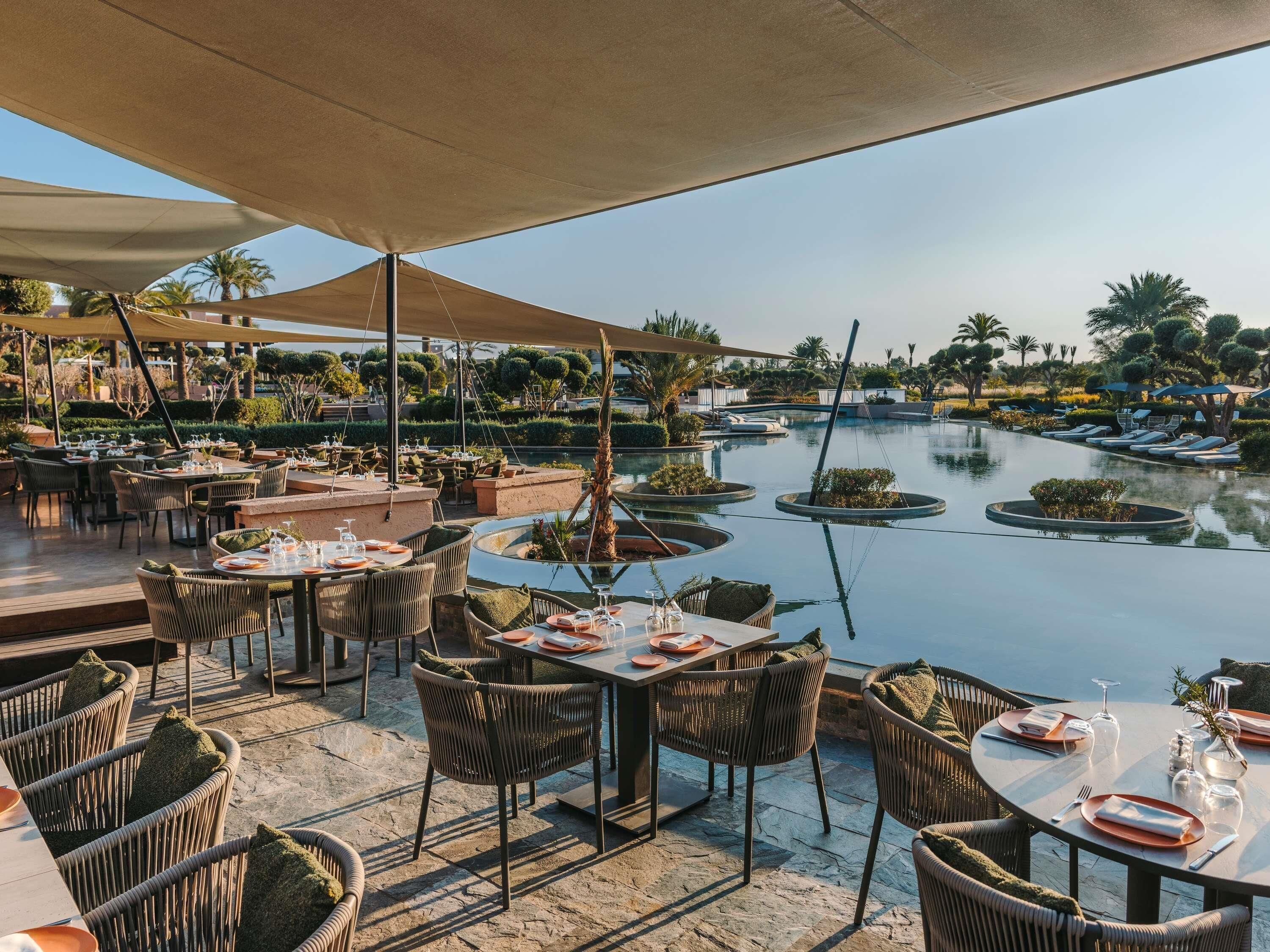 A restaurant with outdoor seating overlooking a pool and marina.