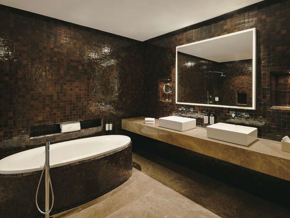 Ein modernes Badezimmer mit einer großzügigen Badewanne, zwei Waschbecken und einem großen Spiegel.