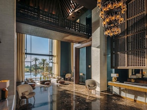 A spacious lobby with a high ceiling, a large chandelier, and a view of palm trees through the windows. - Fairmont Royal Palm Marrakech (Marrakech)