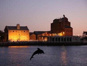 A waterfront building with a large tower and a smaller structure.