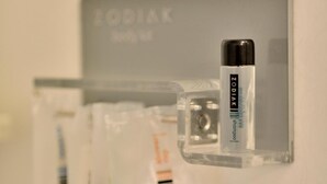 A wall-mounted storage unit with a Zodiac brand container holding a black and silver object, possibly a pen or marker, and a white object, possibly a tissue or handkerchief. - Zodiak Kebonjati by KAGUM Hotels (Bandung)