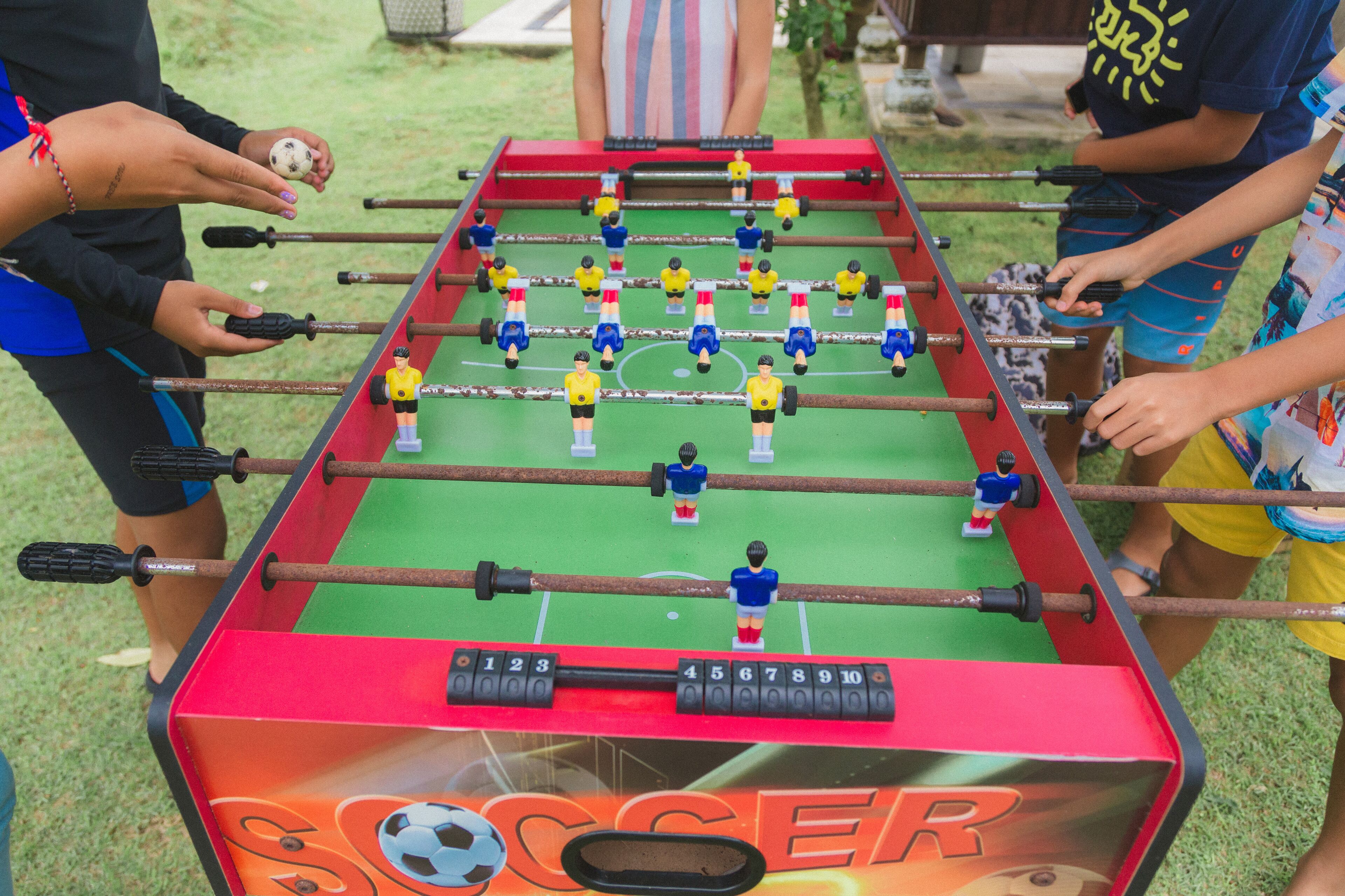A foosball table with players and a soccer ball.