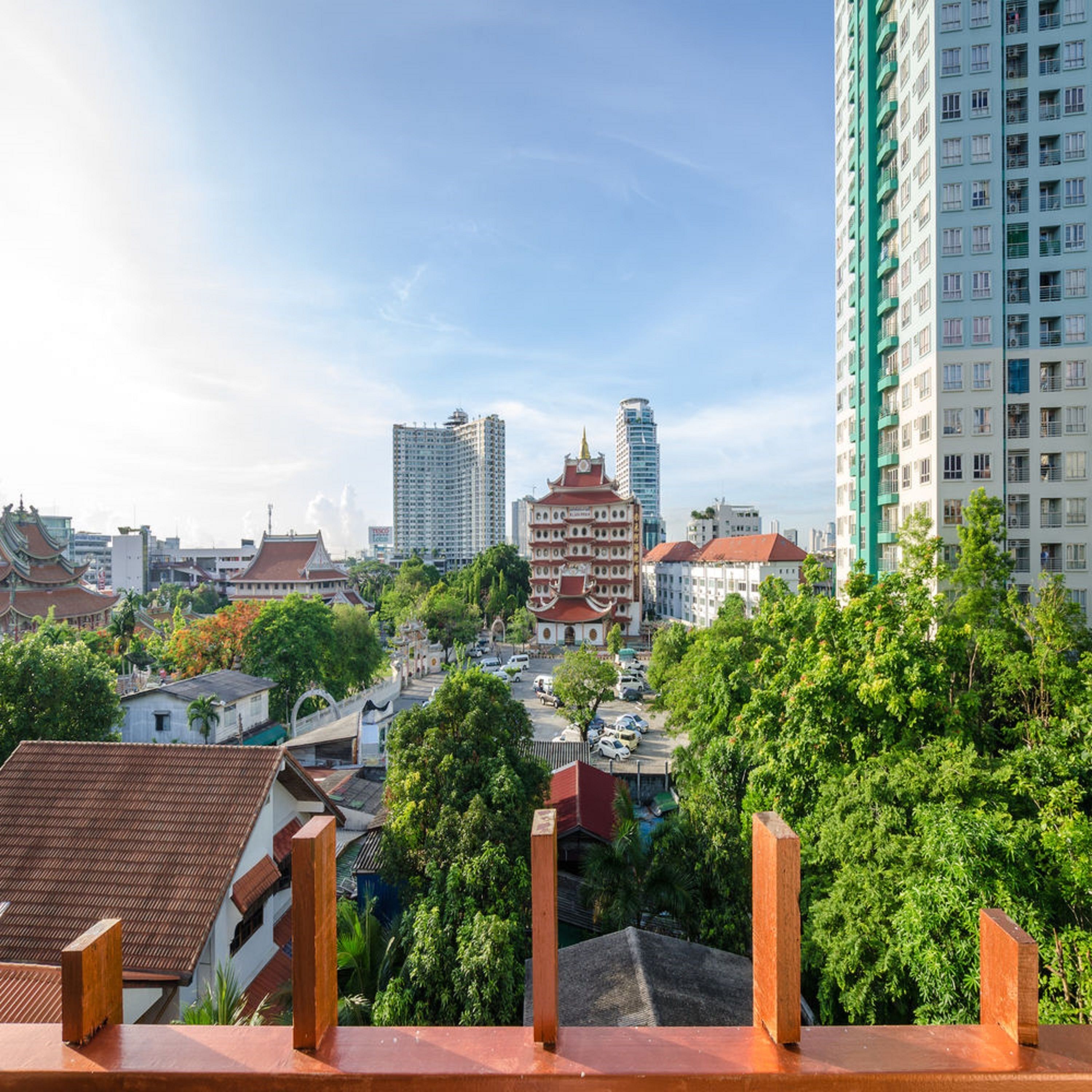 A cityscape with traditional and modern buildings, a prominent temple, and a mix of residential and commercial structures.