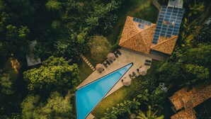 An aerial view of a resort with a swimming pool, lounge area, and solar panels. - Palm Paradise Cabanas & Villas Beach Resort Tangalle (Tangalle)