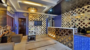 A modern lobby with a reception desk, patterned walls, and a chandelier. - Hotel Blue Pearl (New Delhi)