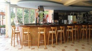 A bar area with wooden stools and a curved counter. - La Luna (Hersonissos)