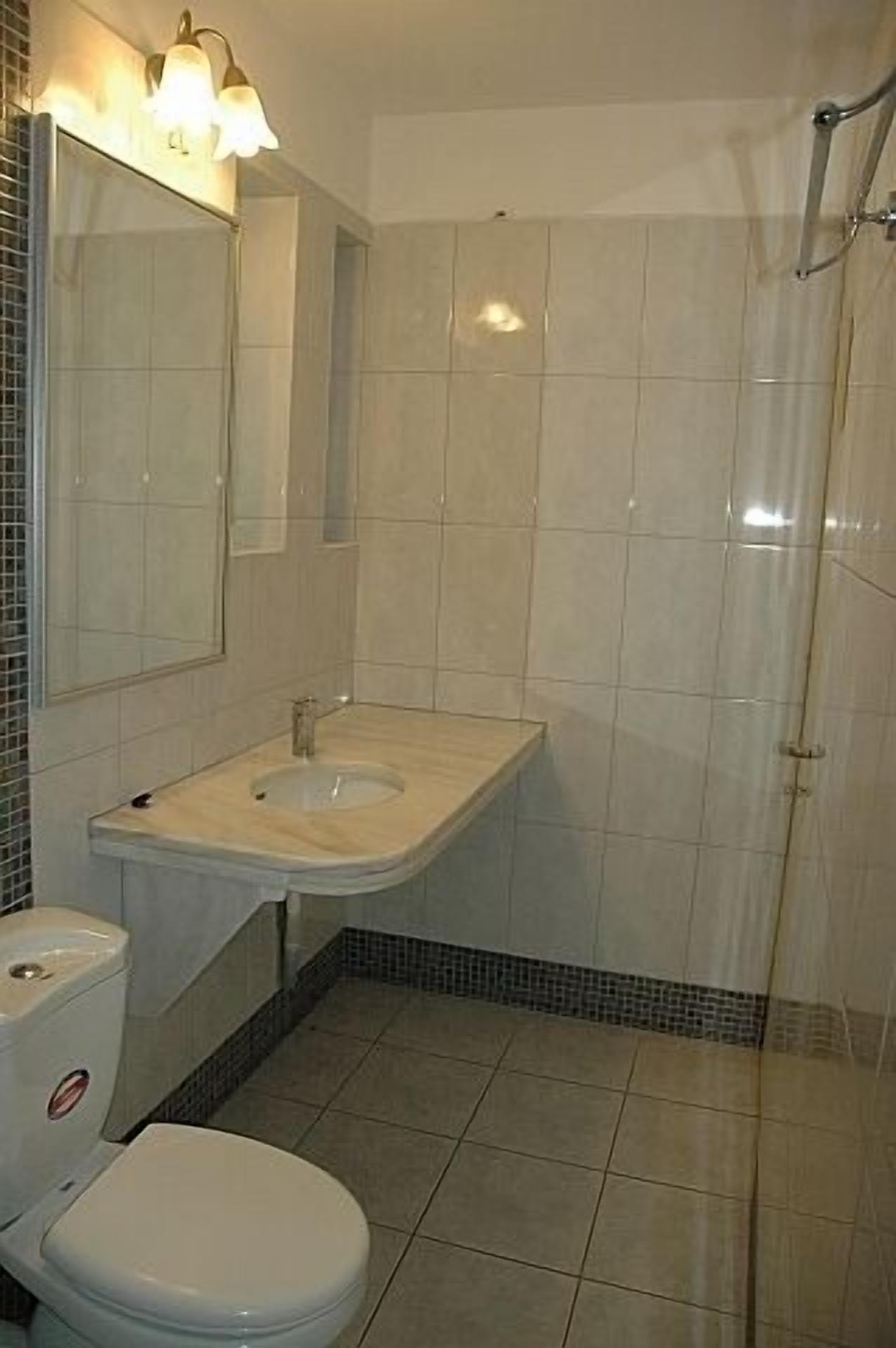 Un baño con inodoro, lavamanos y ducha.