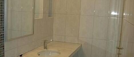 A bathroom with a toilet, sink, and shower.