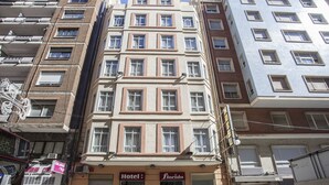 Un hôtel à plusieurs étages, doté d’une façade beige, de nombreuses fenêtres et de balcons.