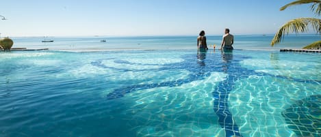 Una piscina al aire libre, sombrillas, sillones reclinables de piscina