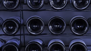 A close-up of wine bottles arranged in a grid on a rack.