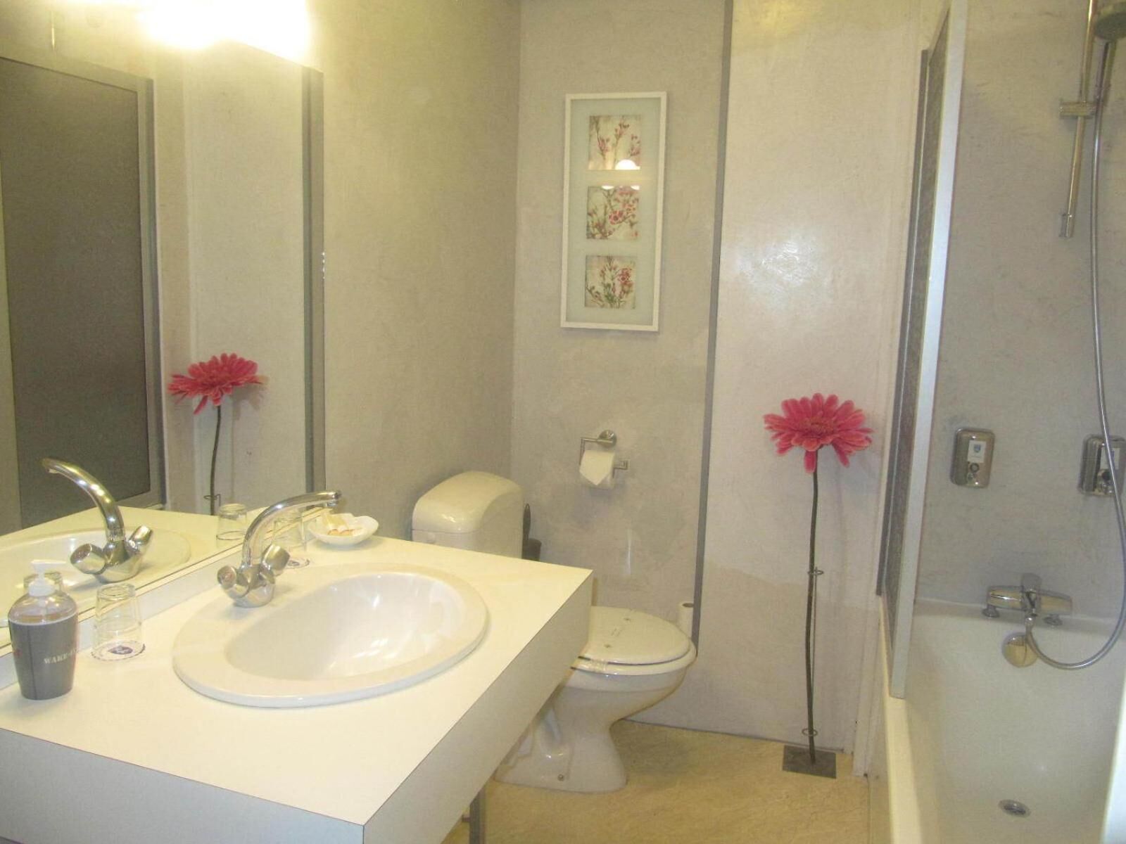 Un baño con lavamanos, inodoro y ducha.