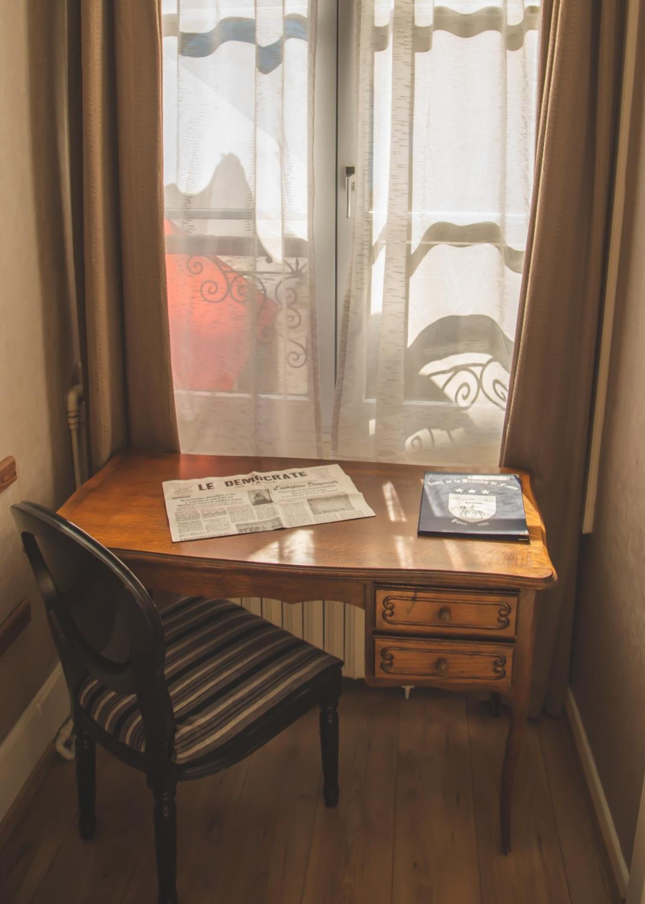 A corner desk with a chair, a newspaper, and a book.