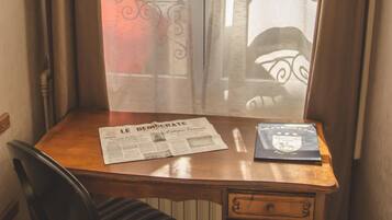 A corner desk with a chair, a newspaper, and a book.