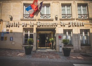 A hotel facade with the name "Hotel de la Gare de France" prominently displayed. There are potted plants at the entrance, and flags are visible above the entrance. - Hotel de la Banniere de France (Laon)