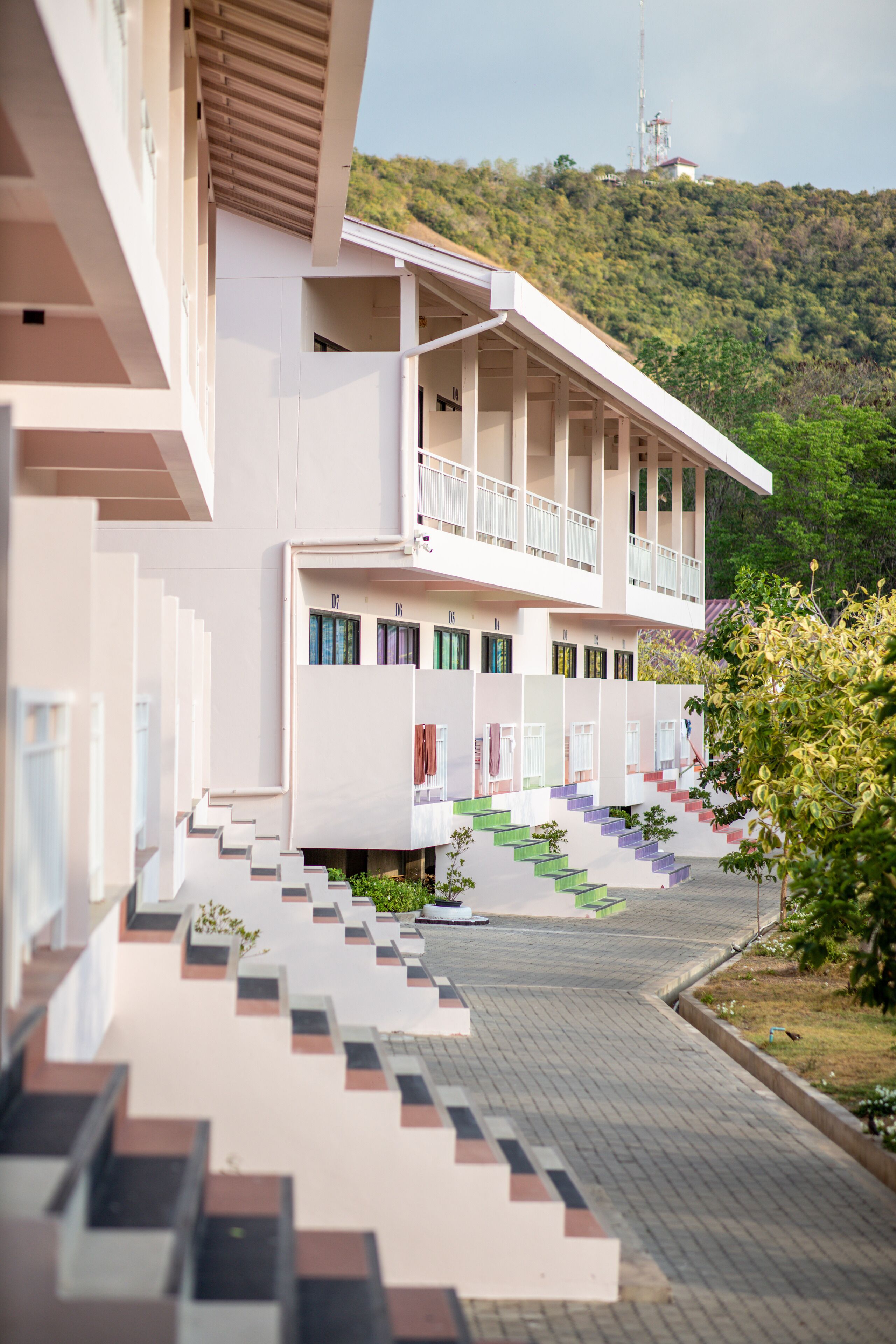 Un bâtiment moderne doté de nombreux balcons et d’un escalier menant à l’entrée.
