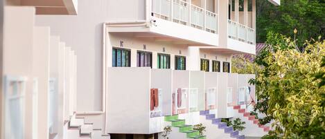 Un bâtiment moderne doté de nombreux balcons et d’un escalier menant à l’entrée.