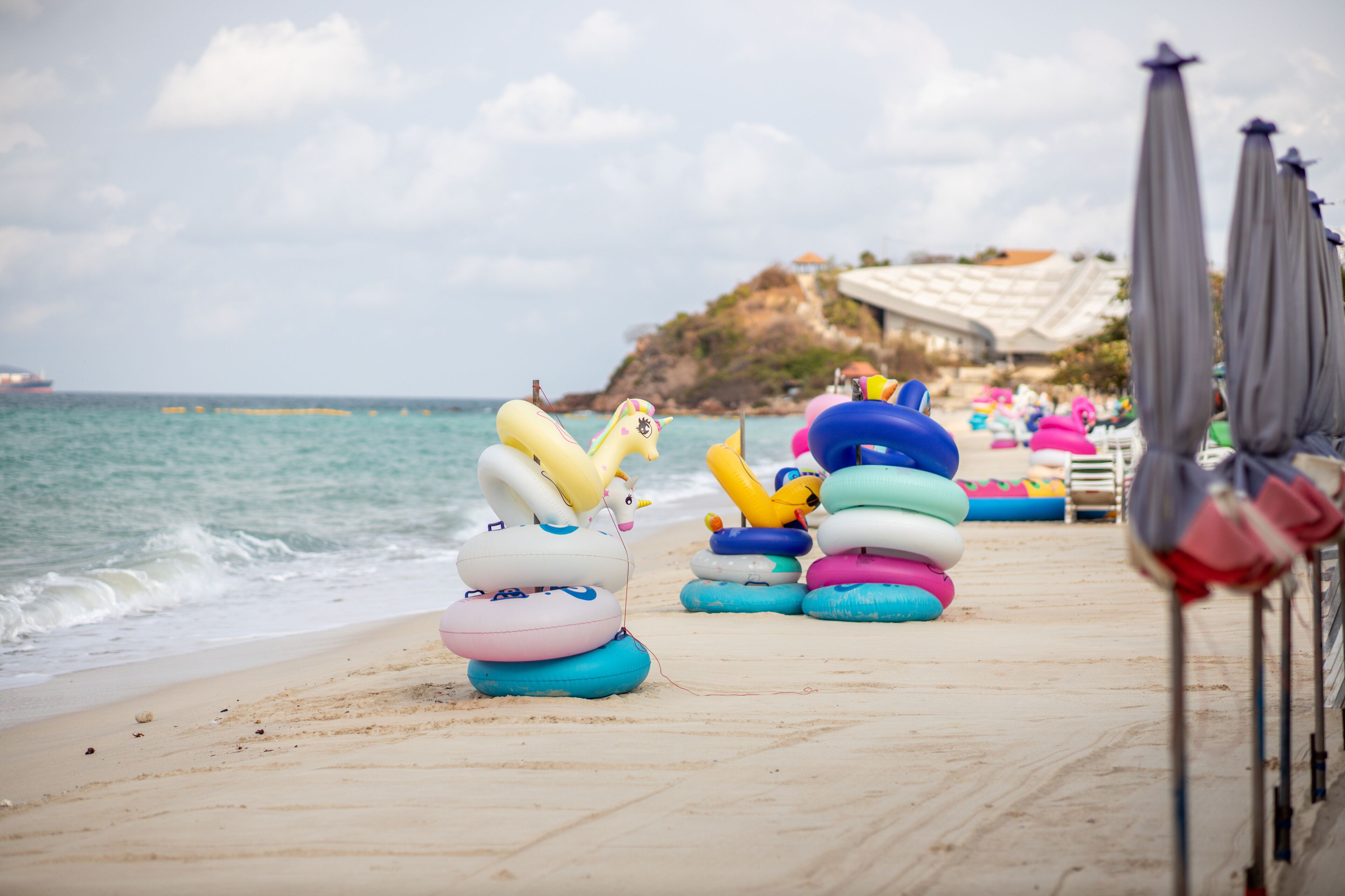 Une zone de plage aménagée avec des jeux gonflables et des parasols.