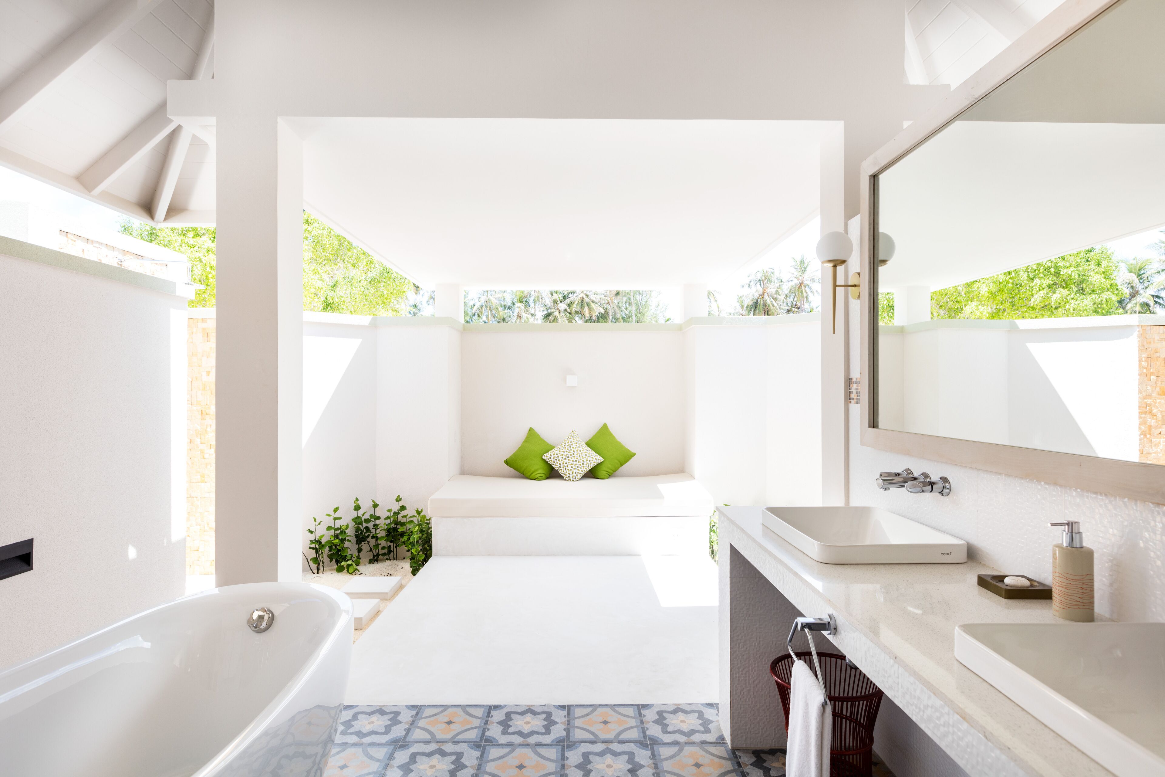 Un baño moderno con bañera, lavabo y un espejo grande.