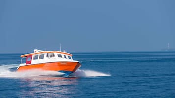 Una embarcación de casco blanco y naranja deslizándose sobre el agua.