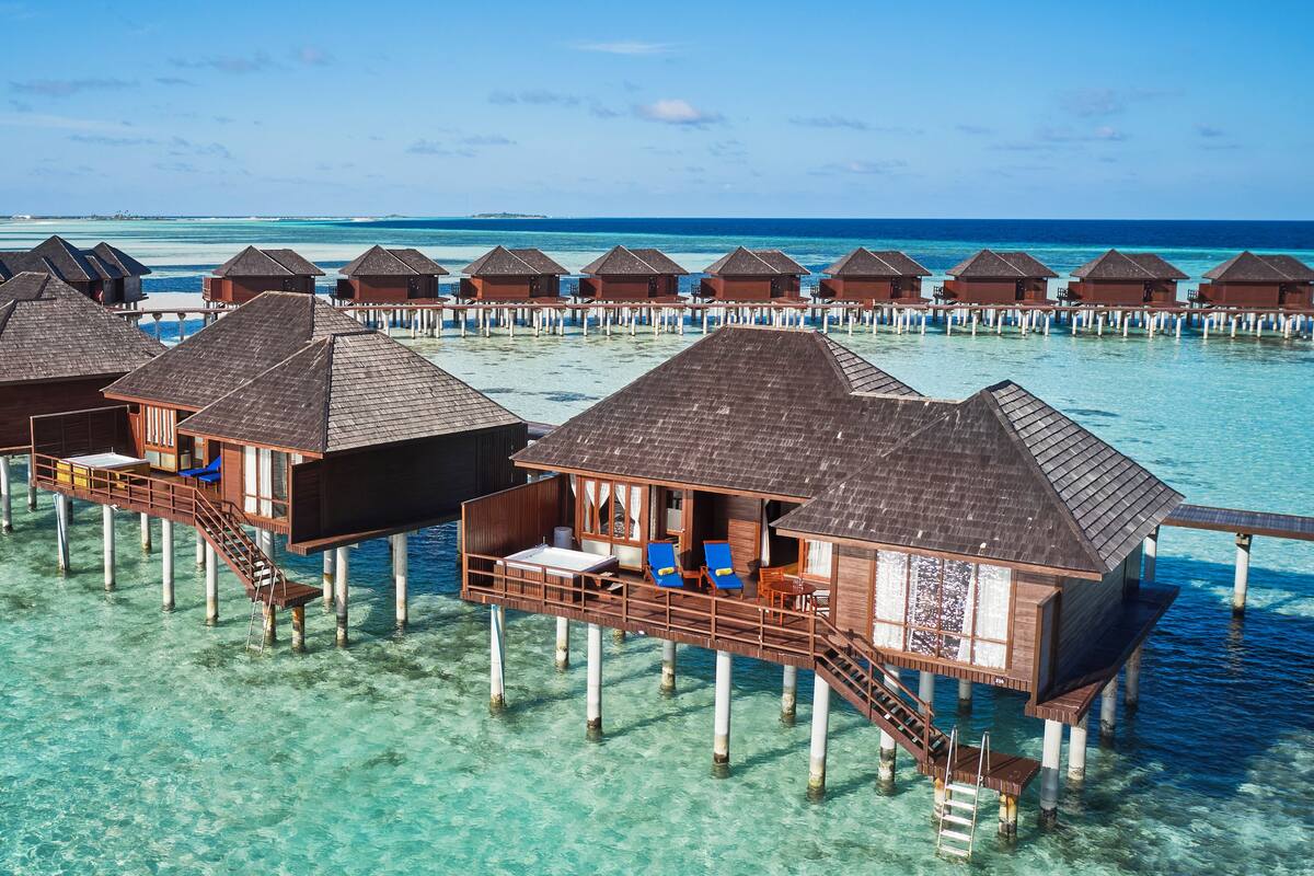 Bungalows sobre el agua con terrazas de madera y aguas cristalinas azules.