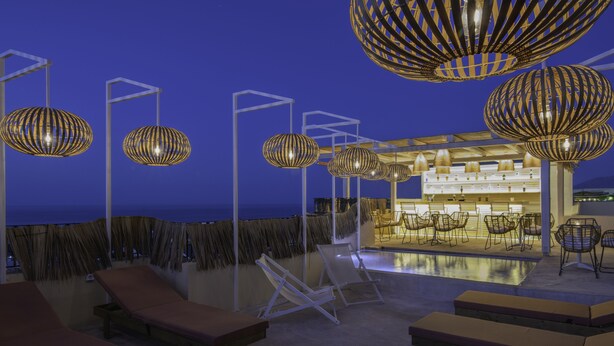 A rooftop bar with lounge chairs and hanging spherical light fixtures. - Villa Elite by Checkin (Hersonissos)