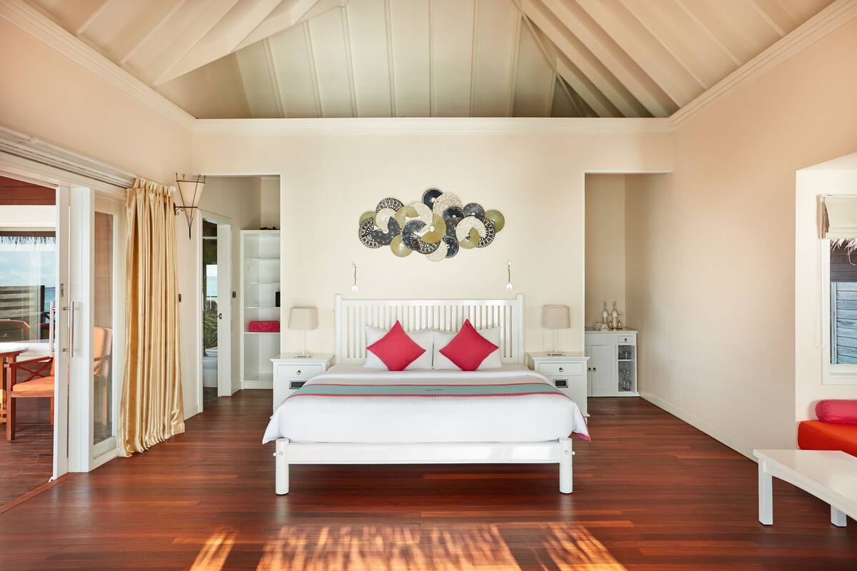 Ein geräumiges Schlafzimmer mit einem großen Bett, einem Deckenventilator und Blick auf den Balkon.