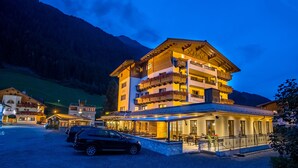 A multi-story hotel with a restaurant on the ground floor, surrounded by a mountainous landscape. - Hotel Lenz (See)