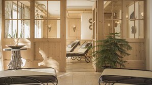 A room with wooden walls, a potted plant, and two reclining chairs. - Hotel Lenz (See)