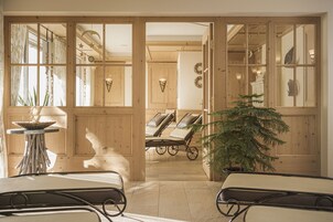 A room with wooden walls, a potted plant, and two reclining chairs.